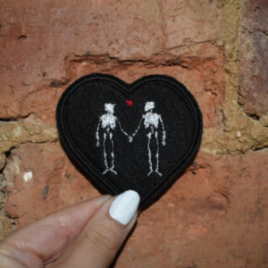 black heart shaped embroidered patch with skeletons
